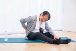 腰をさすっている高齢男性