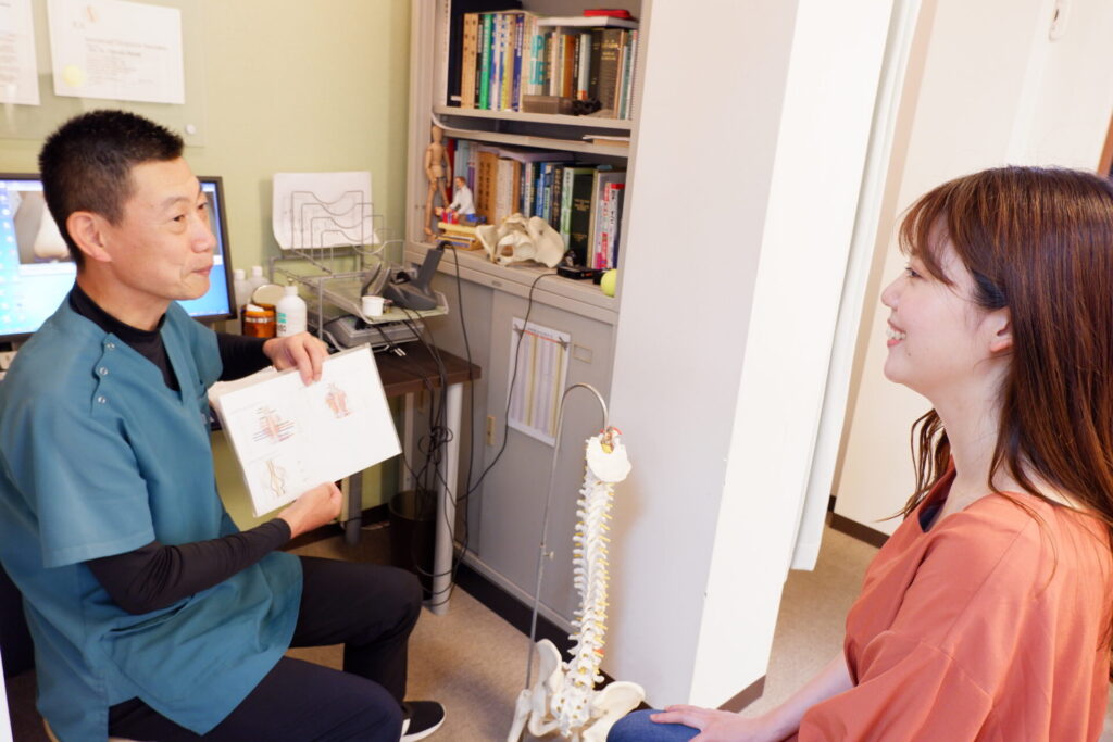 グリーンPCTカイロプラクティックで説明を受けている女性